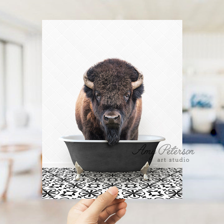 a hand holding up a card with a picture of a bison in a bathtub