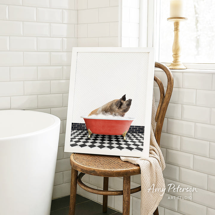 A framed image of a pig sitting in a red bathtub, surrounded by a black and white checkered floor, is displayed on a wooden chair in a bathroom setting.
