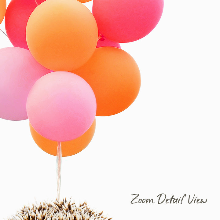 A group of colorful balloons, including pink, orange, and yellow ones, floating in the air.