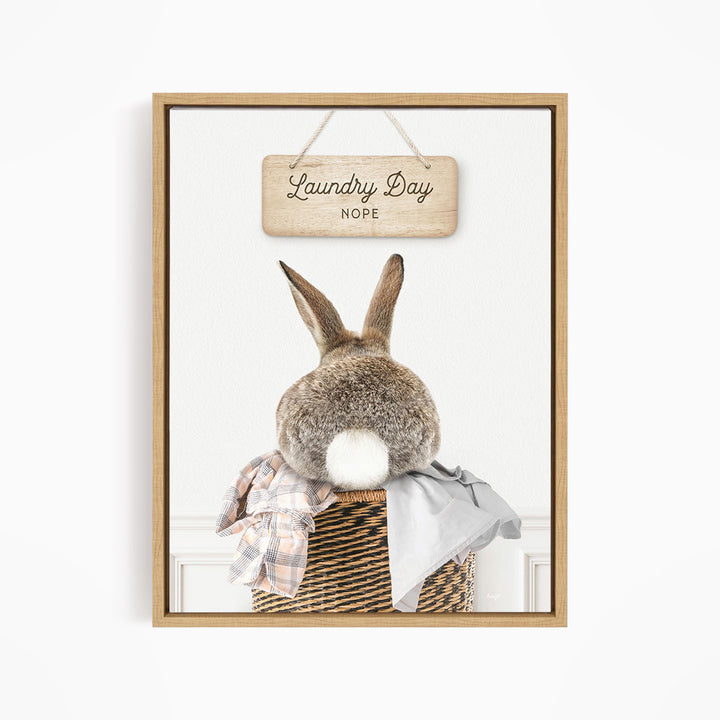 A wooden sign with the text "Laundry Day NOPE" hangs above a wicker basket containing clothes.