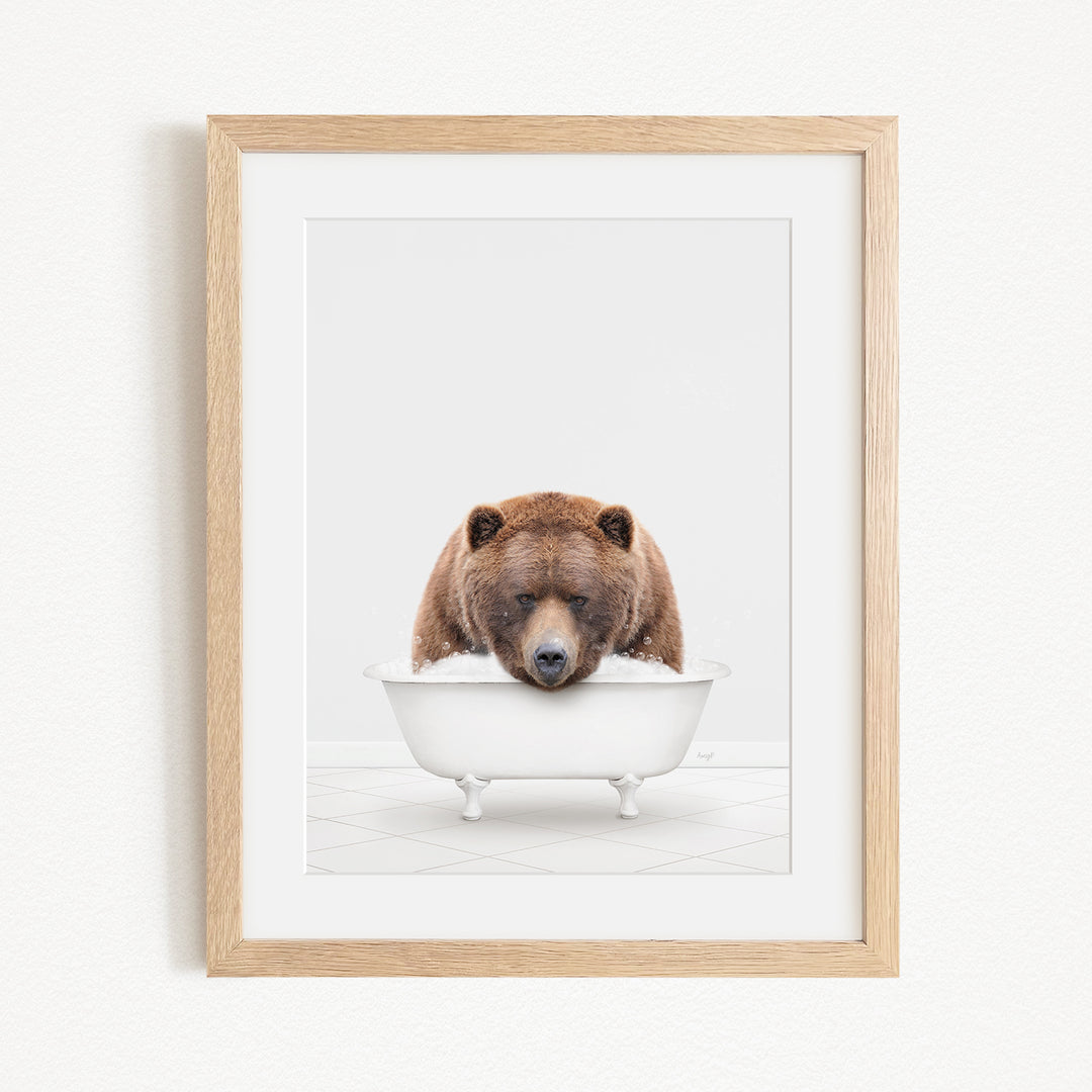A brown bear is sitting in a white bathtub, appearing to be enjoying a relaxing bath.