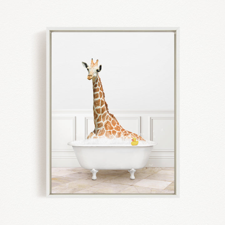 A giraffe sitting in a white bathtub filled with water, with a yellow rubber duck floating in the water.