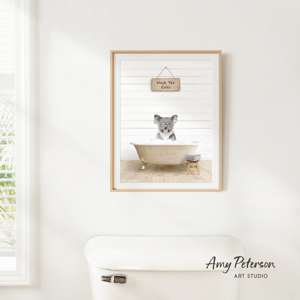 A framed image of a koala sitting in a bathtub, with a sign above it that says "Wash Your Cat".