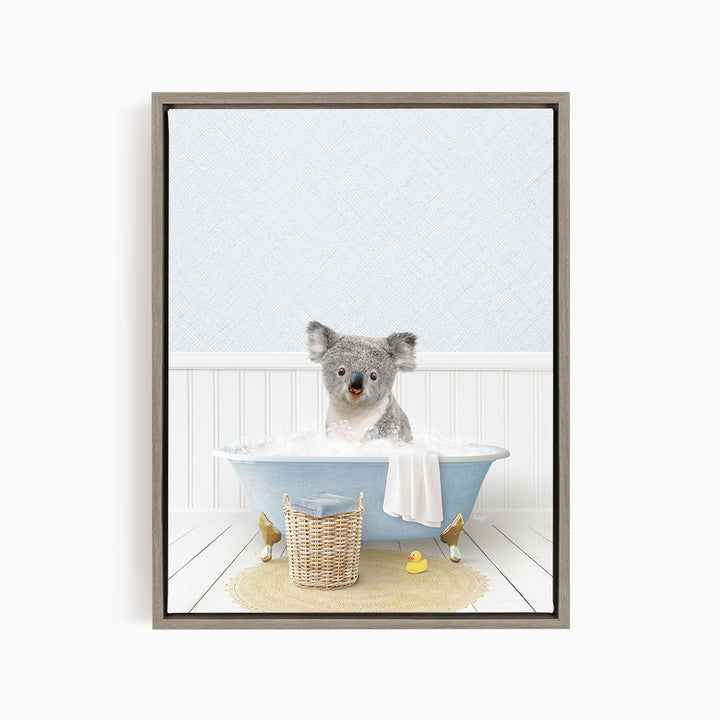A koala bear sitting in a blue bathtub filled with water, surrounded by a yellow rubber duck and a basket.