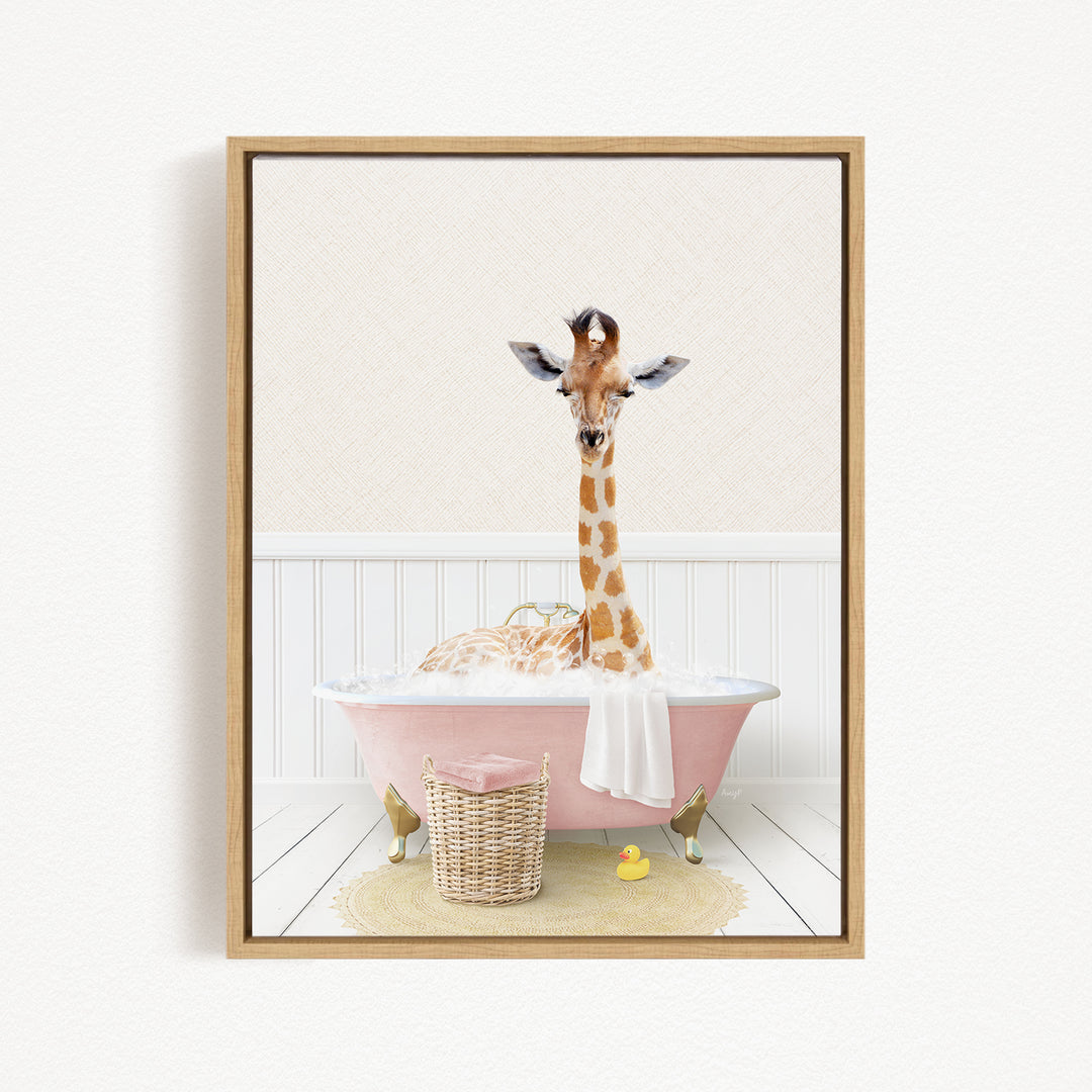 A giraffe is sitting in a pink bathtub filled with water, surrounded by a basket of rubber ducks and a white towel.