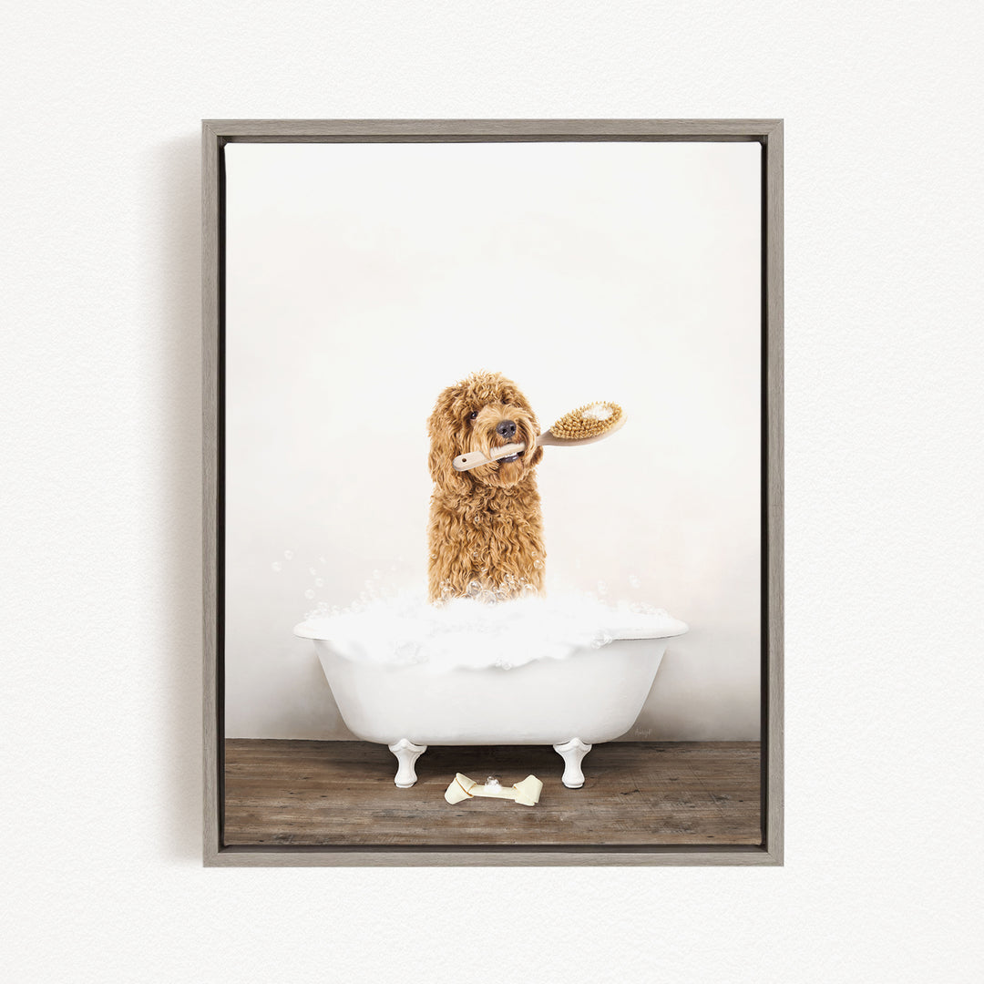A brown dog is sitting in a white bathtub filled with bubbles, holding a toothbrush in its mouth.
