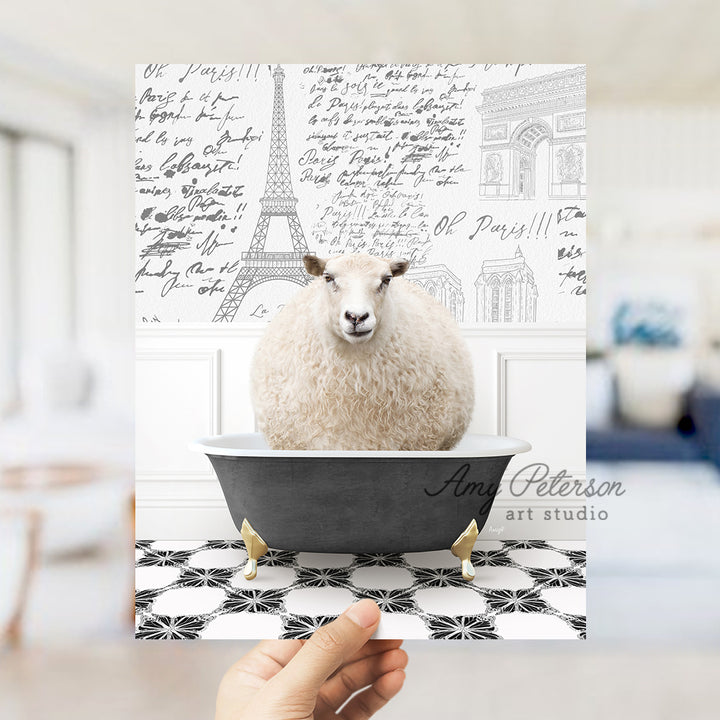 a hand holding a card with a picture of a sheep in a bathtub