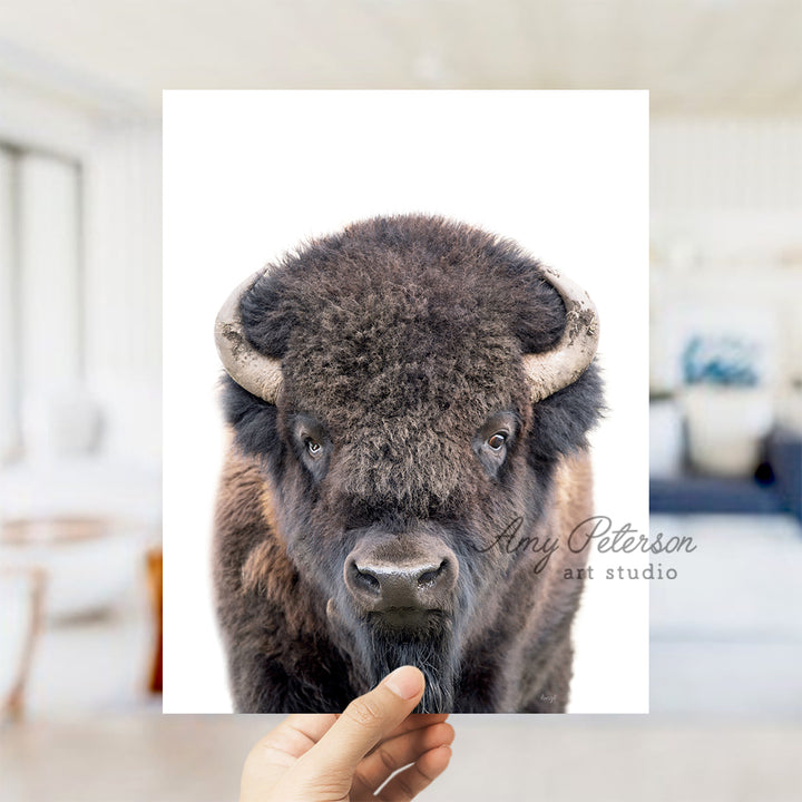 a person holding up a picture of a bison