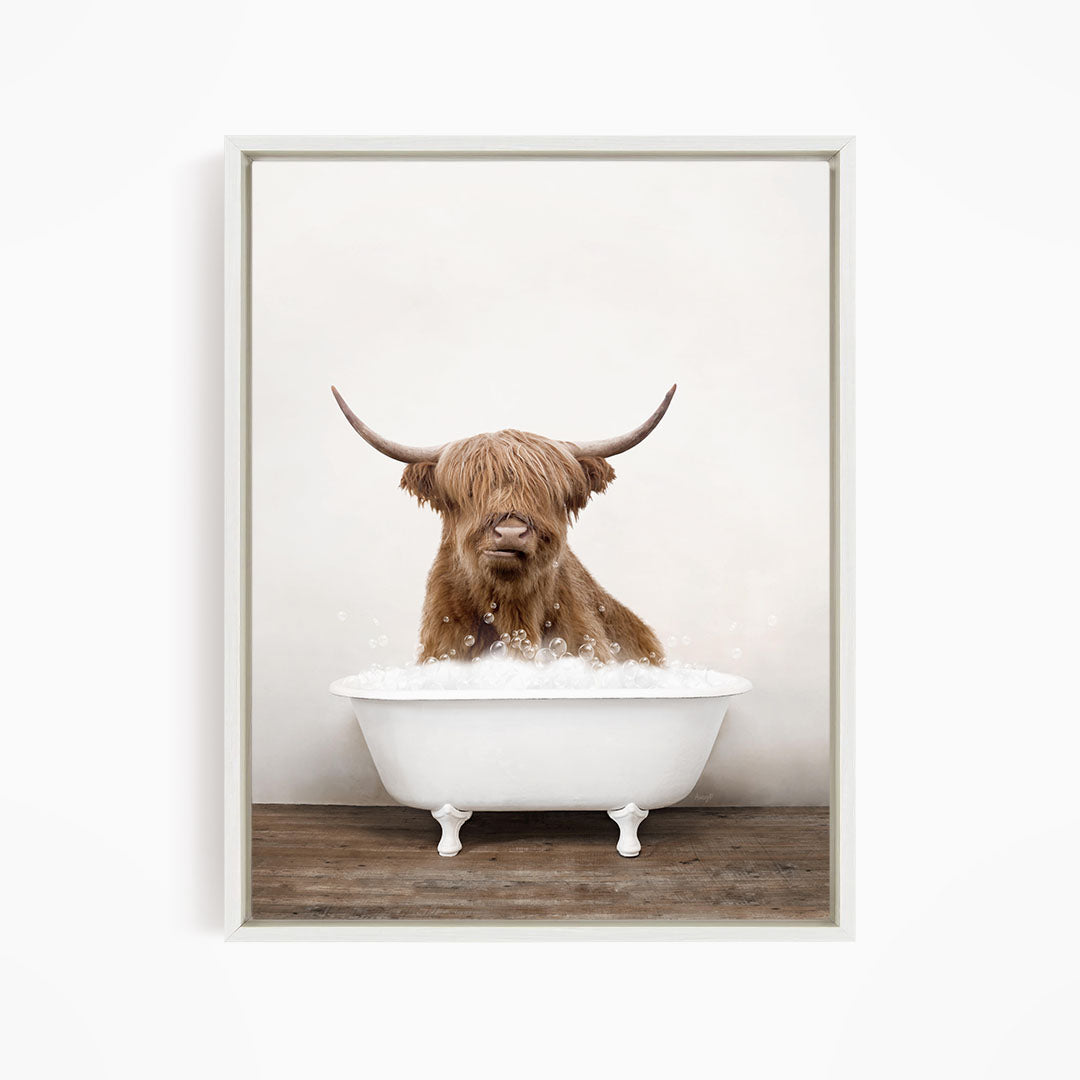A brown Highland cow with long horns is sitting in a white bathtub filled with water, creating a whimsical and playful scene.
