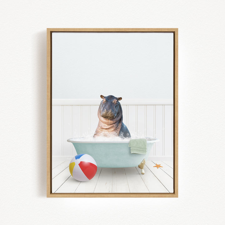 A framed image depicting a hippopotamus sitting in a bathtub filled with water, surrounded by a beach ball and a towel.