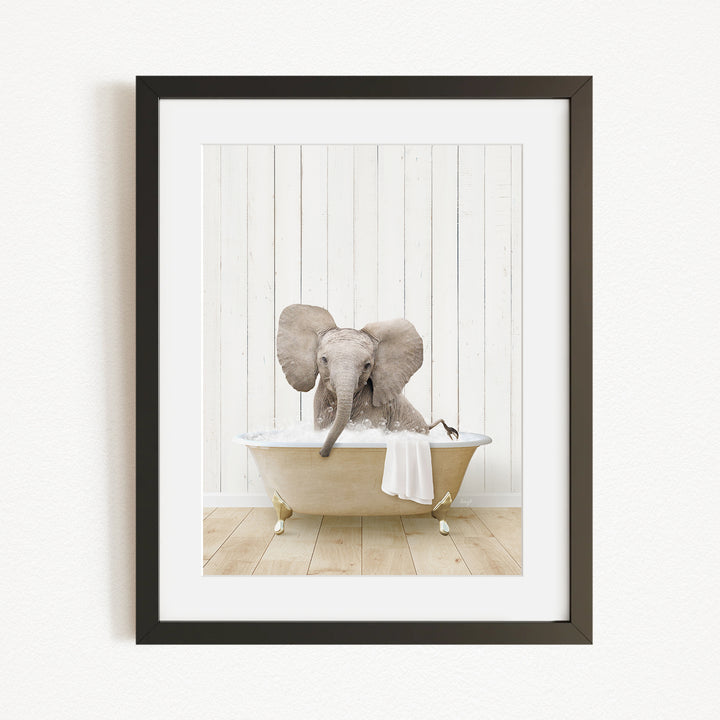 A baby elephant sitting in a bathtub filled with water, with its trunk raised and ears flapping.