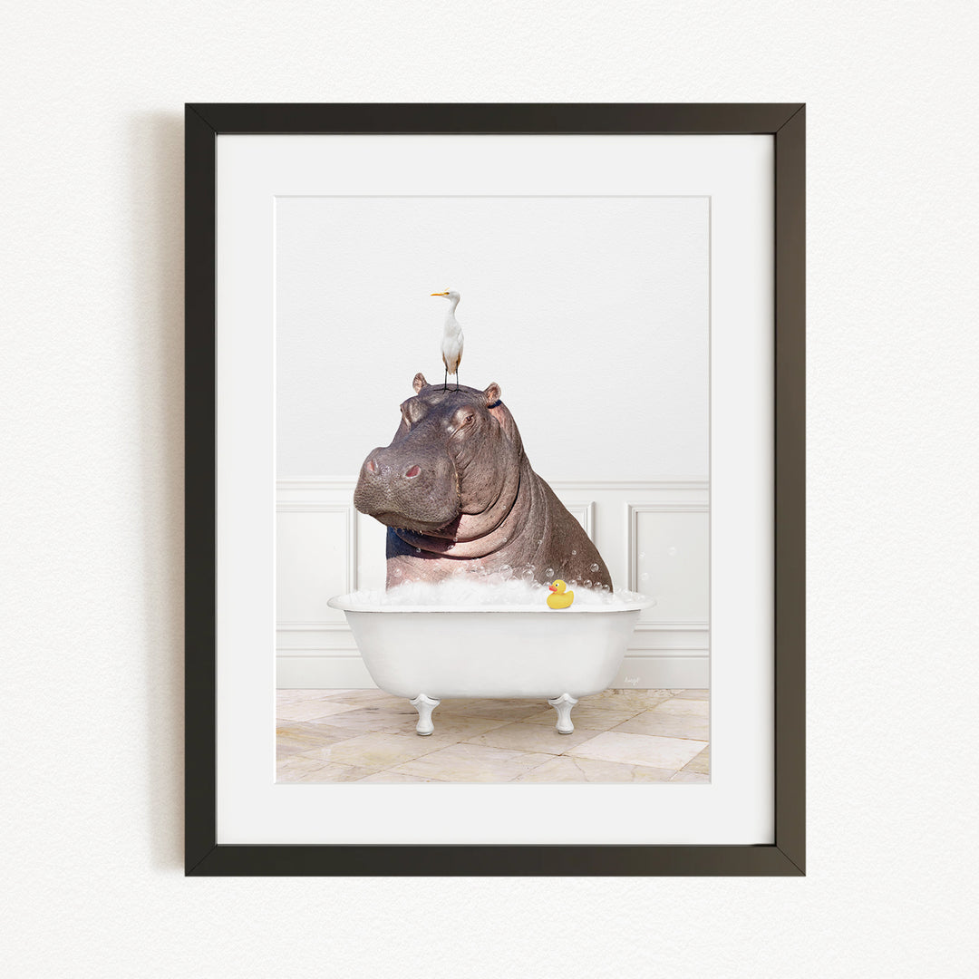 A framed image depicting a hippopotamus sitting in a bathtub, with a seagull perched on its head.
