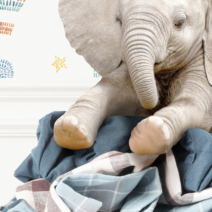 a stuffed elephant sitting on top of a blanket