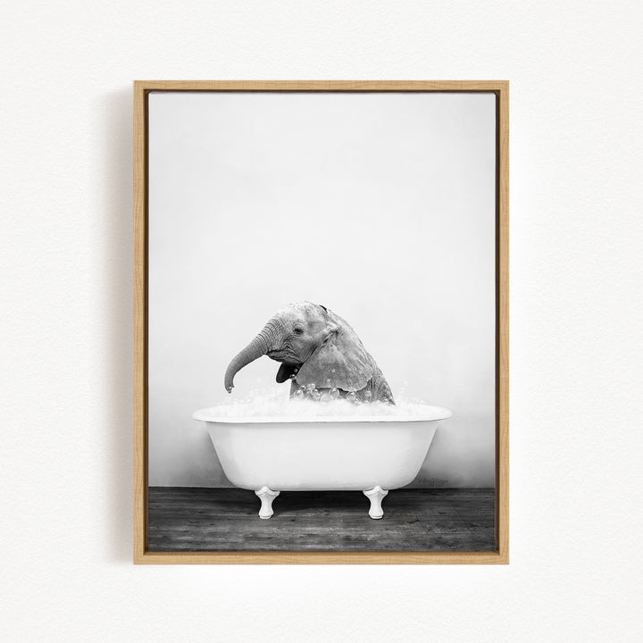 A black and white photograph of an elephant sitting in a bathtub filled with water.