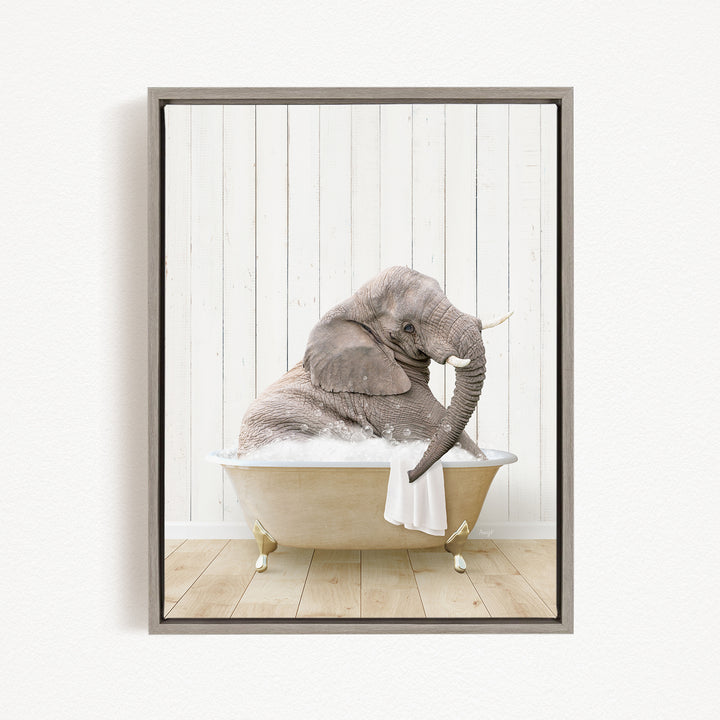 A gray elephant is sitting in a white bathtub filled with water, with its trunk raised and appearing to be enjoying the bath.