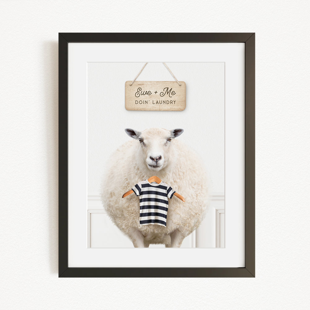 A framed image of a sheep standing in front of a sign that says "Euse + Me Doin Laundry".