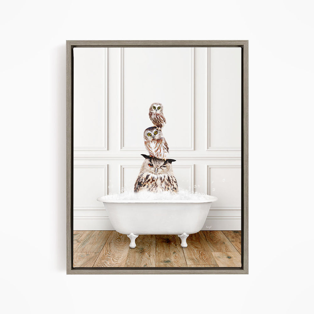 A framed image depicting three owls sitting in a white bathtub, with one owl sitting on top of the other two.