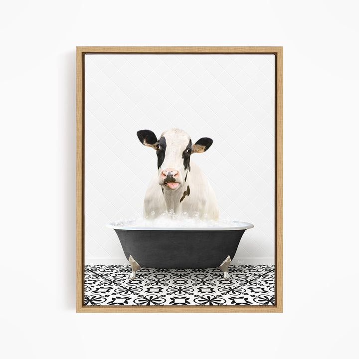 A black and white cow is sitting in a black bathtub filled with water, creating a whimsical and humorous scene.