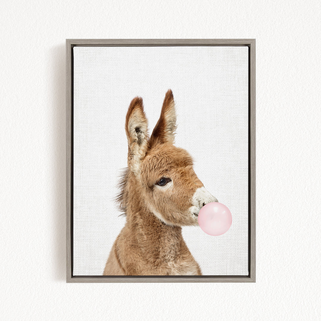 A donkey blowing a bubble with a pink bubble gum bubble.