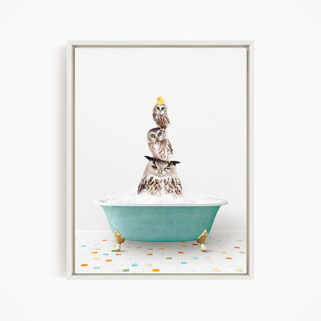 A framed image depicting three owls sitting in a green bathtub filled with bubbles, with one of the owls wearing a yellow hat.