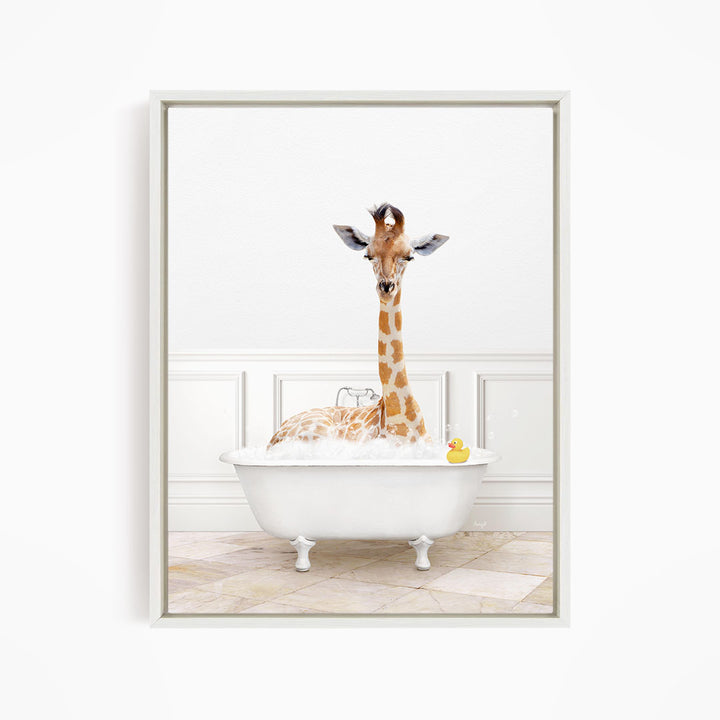 A giraffe sitting in a white bathtub filled with bubbles, with a yellow rubber duck floating in the water.