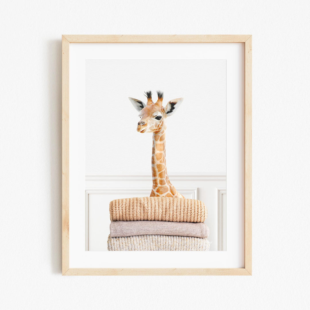 a giraffe standing on top of a pile of clothes