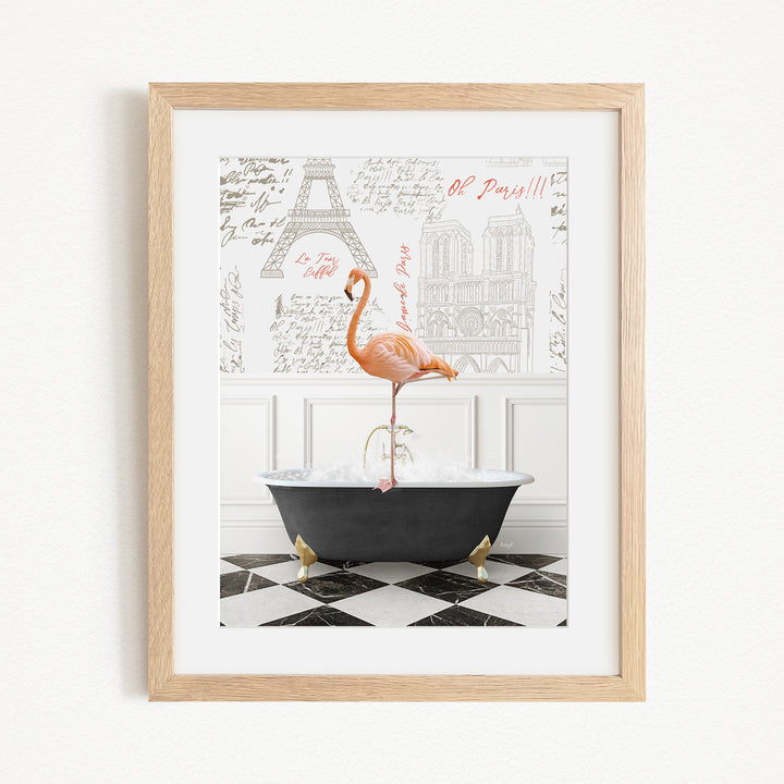 A framed image depicting a pink flamingo standing in a bathtub, with a black and white checkered floor and a framed image of the Eiffel Tower in the background.