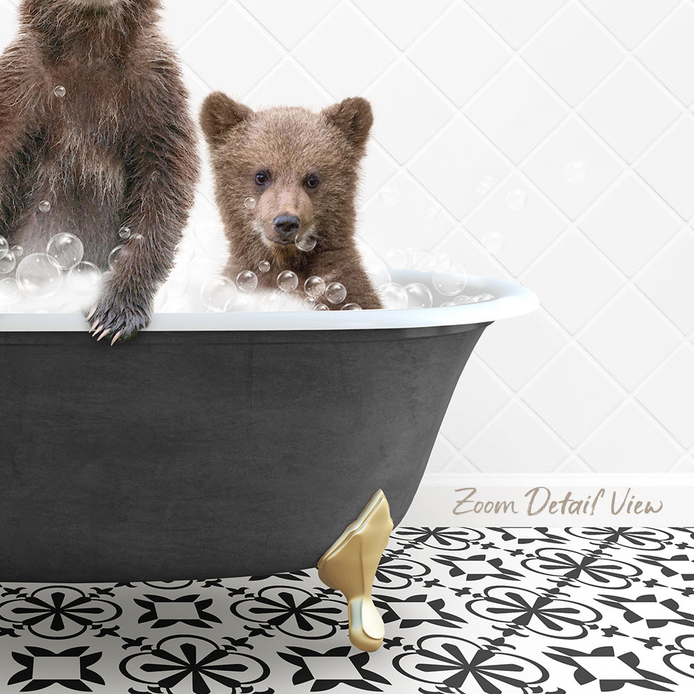 A baby bear sitting in a bathtub filled with bubbles, with a gold bathtub faucet and a black and white patterned floor in the background.