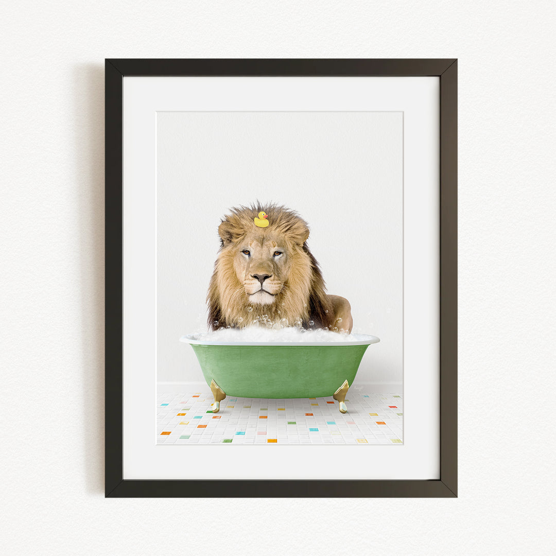A lion is sitting in a green bathtub filled with bubbles, with a yellow rubber duck floating on the water.