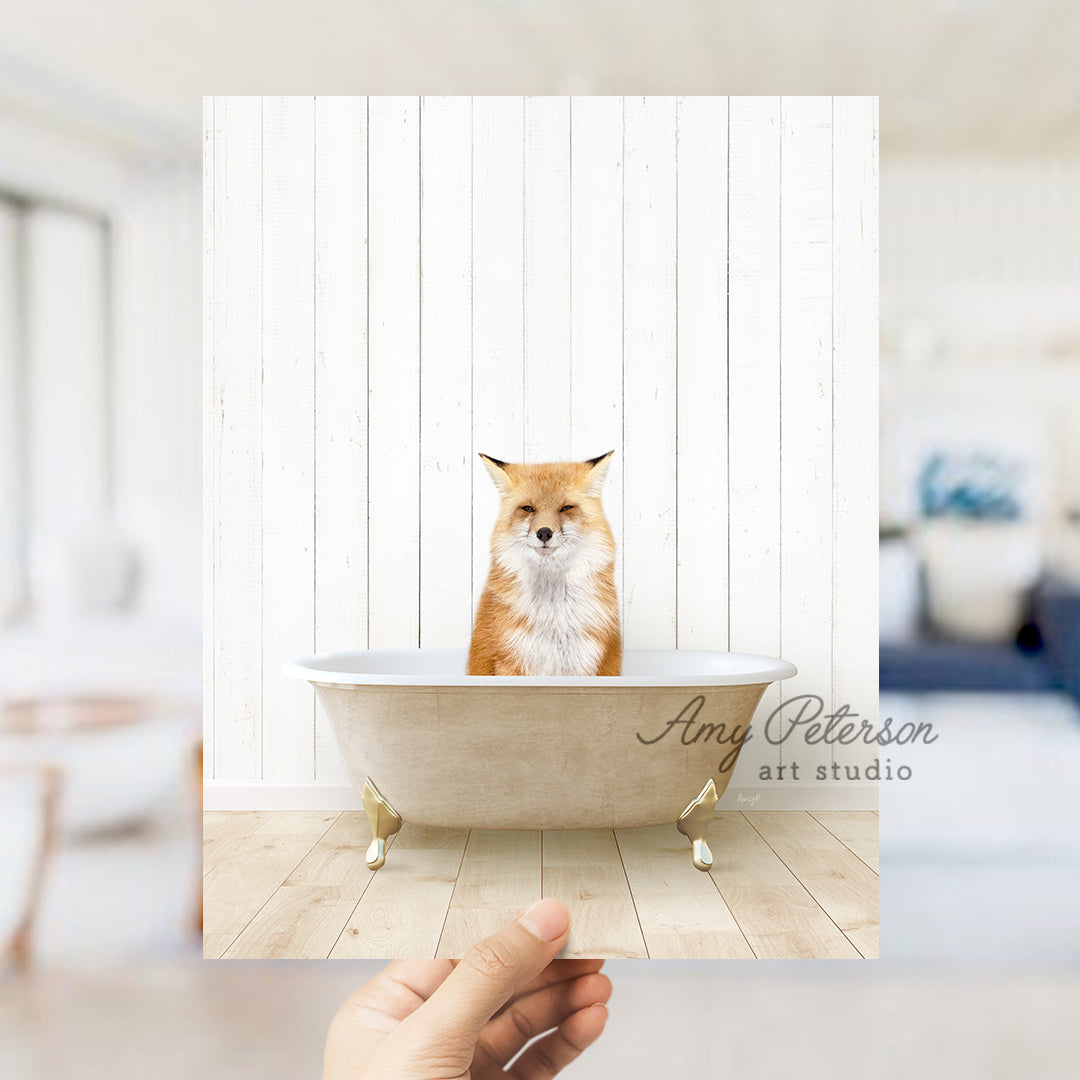 a hand holding a photo of a fox in a bathtub