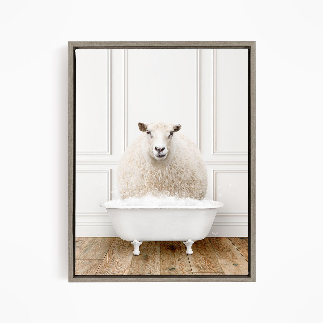 A fluffy white sheep sits in a white bathtub filled with bubbles, looking directly at the camera.