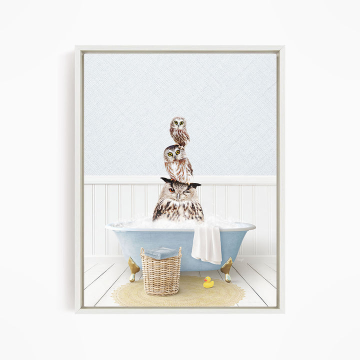A framed image depicting three owls sitting in a bathtub filled with water, with a yellow rubber duck floating nearby.