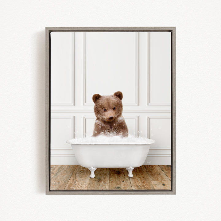 A brown bear sitting in a white bathtub filled with bubbles, looking directly at the camera.