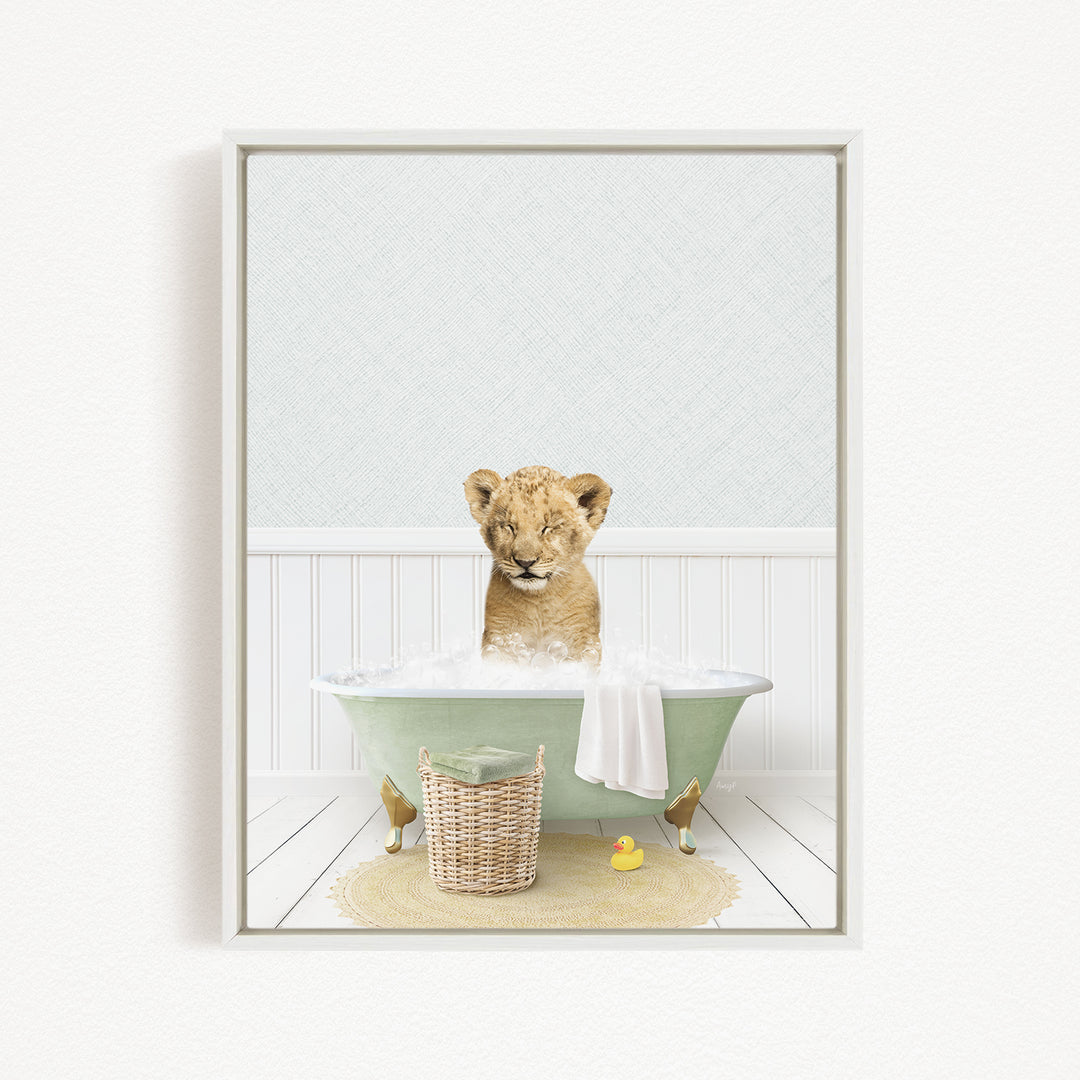 A young lion cub sitting in a green bathtub filled with bubbles, surrounded by a basket of toys and a yellow rubber duck.