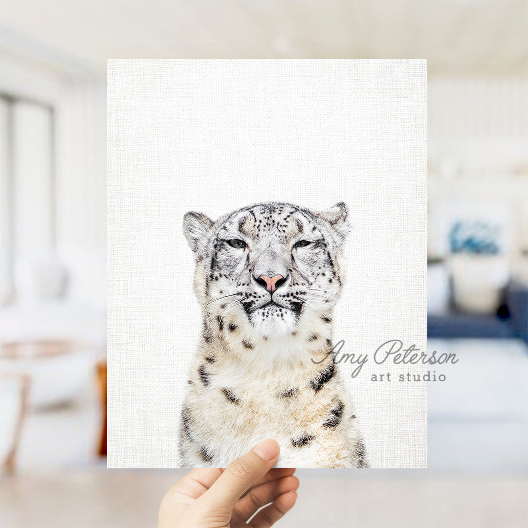 a hand holding a card with a picture of a snow leopard