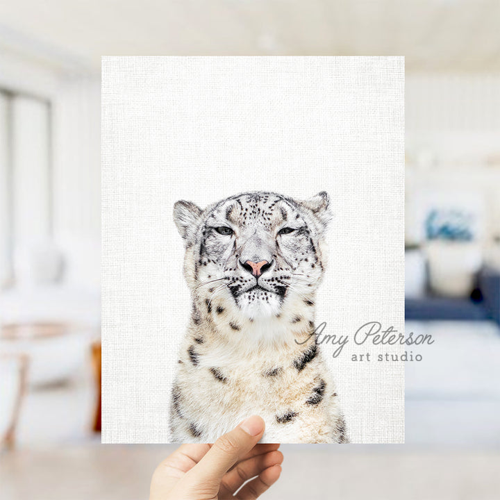 a hand holding a card with a picture of a snow leopard