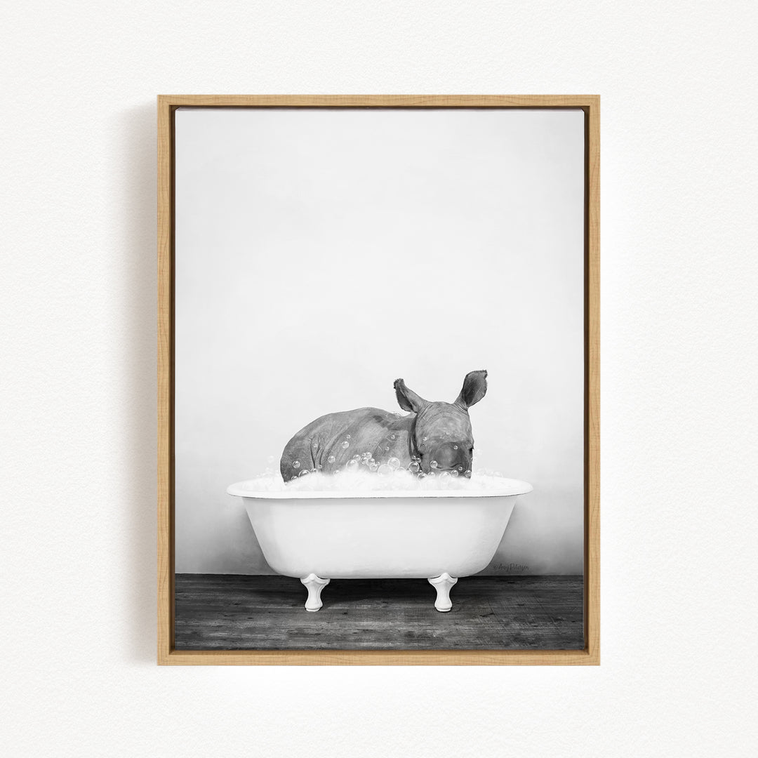 A rhinoceros is sitting in a bathtub filled with water, creating a whimsical and playful scene.