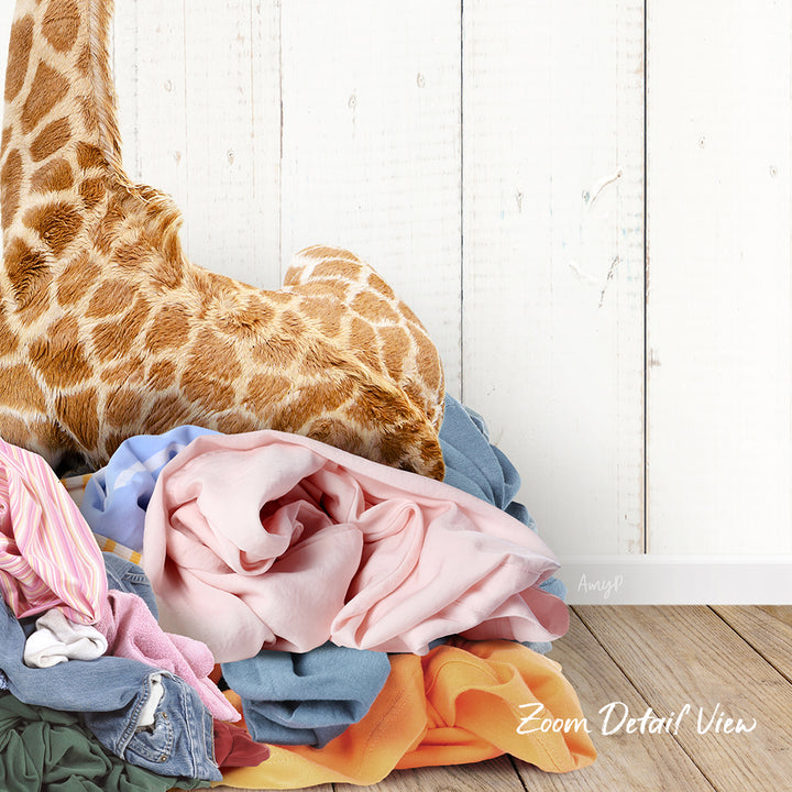 A pile of colorful clothes, including a giraffe stuffed animal, is displayed against a white wooden background.