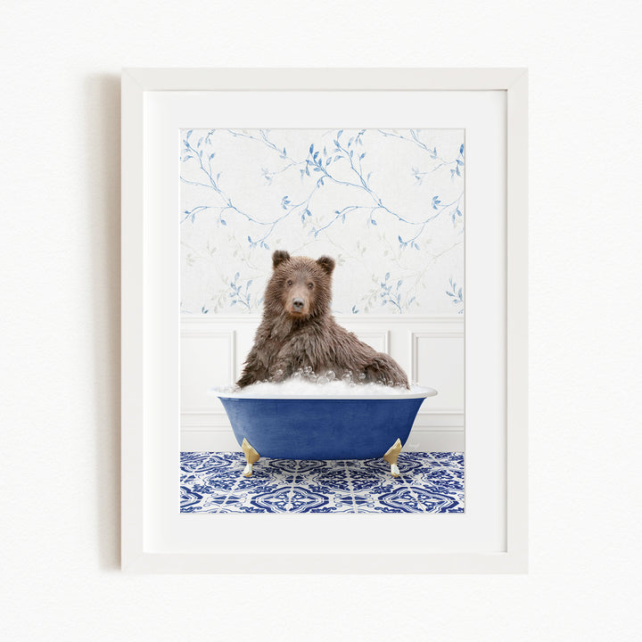 A brown bear sitting in a blue bathtub filled with bubbles, with a patterned tile floor and a floral wallpaper in the background.