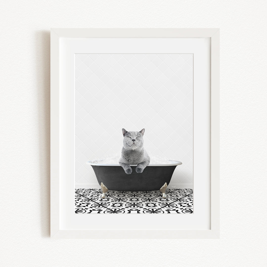 A gray cat sitting in a black bathtub, with a patterned tile floor in the foreground.