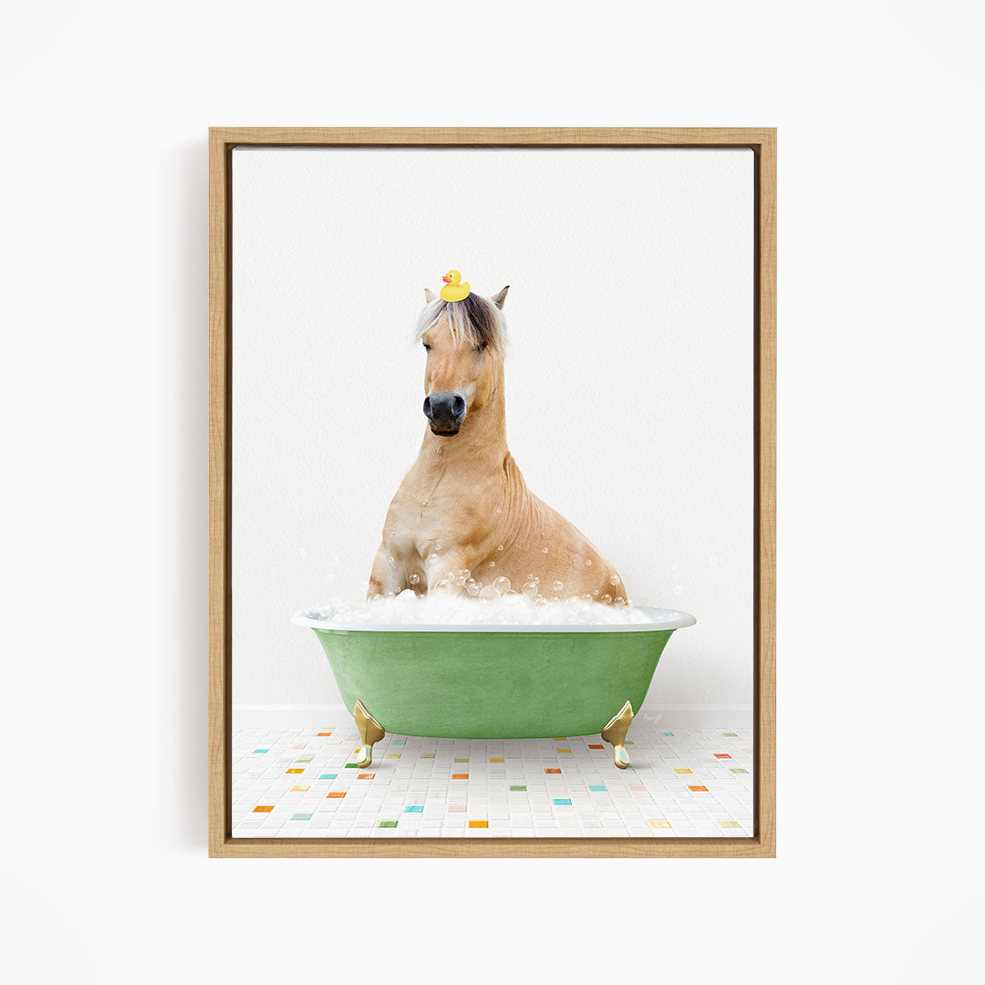 A light brown horse is sitting in a green bathtub filled with bubbles, with a rubber duck perched on its head.