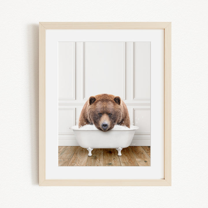 A brown bear is sitting in a white bathtub, appearing to be enjoying a relaxing bath.