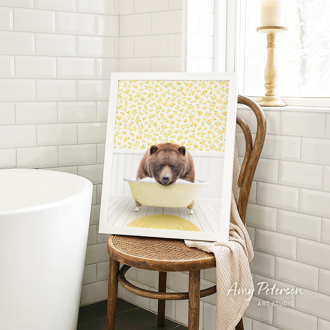 A framed image of a bear sitting in a bathtub, with a yellow floral pattern on the wall behind it.
