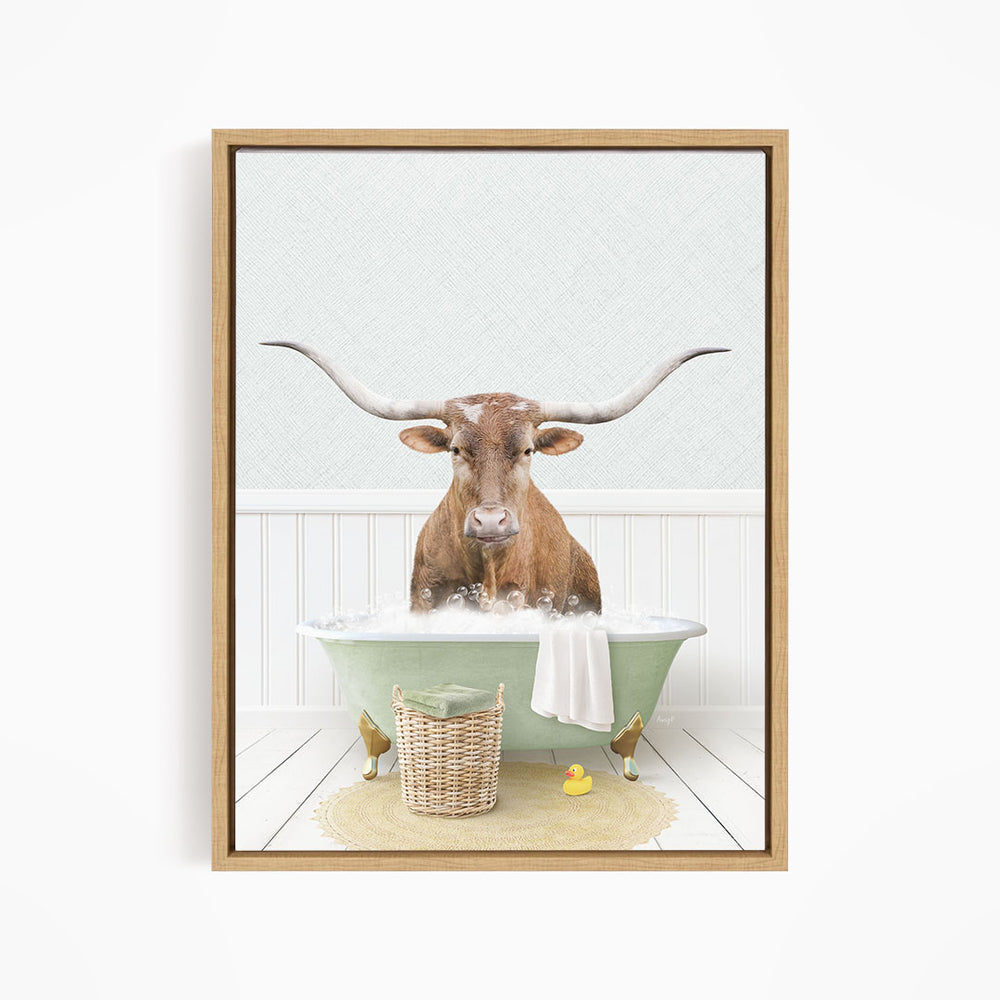A brown bull with long horns is sitting in a green bathtub filled with bubbles, surrounded by a basket of rubber ducks and a towel.