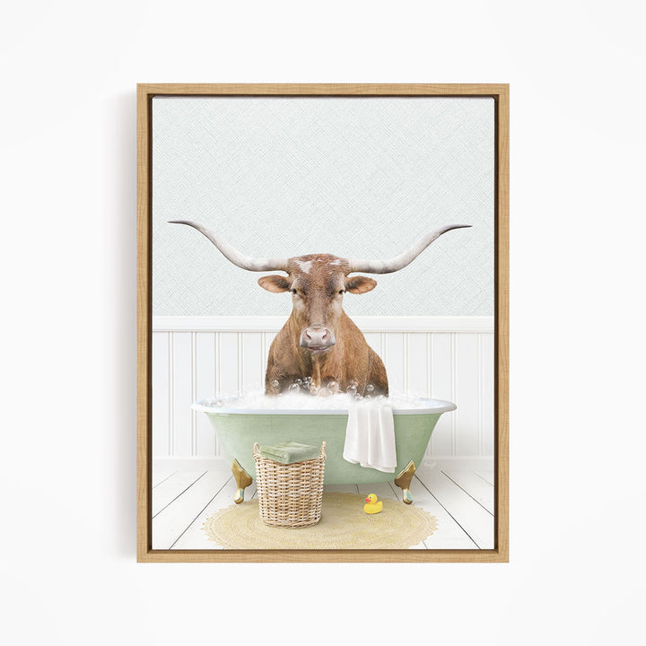 A brown bull with long horns is sitting in a green bathtub filled with bubbles, surrounded by a basket of rubber ducks and a towel.