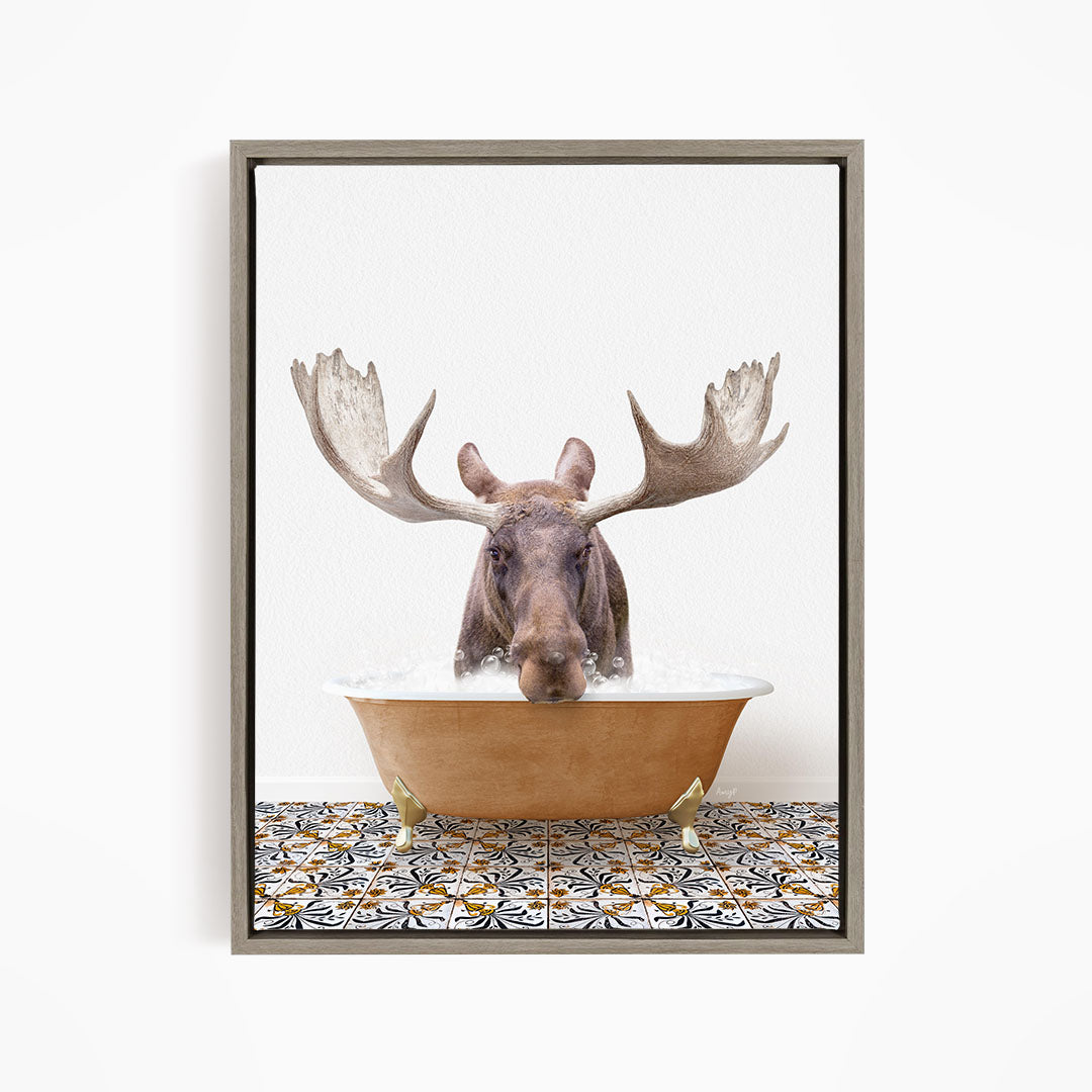 A moose with large antlers is sitting in a bathtub filled with water, creating a whimsical and humorous scene.