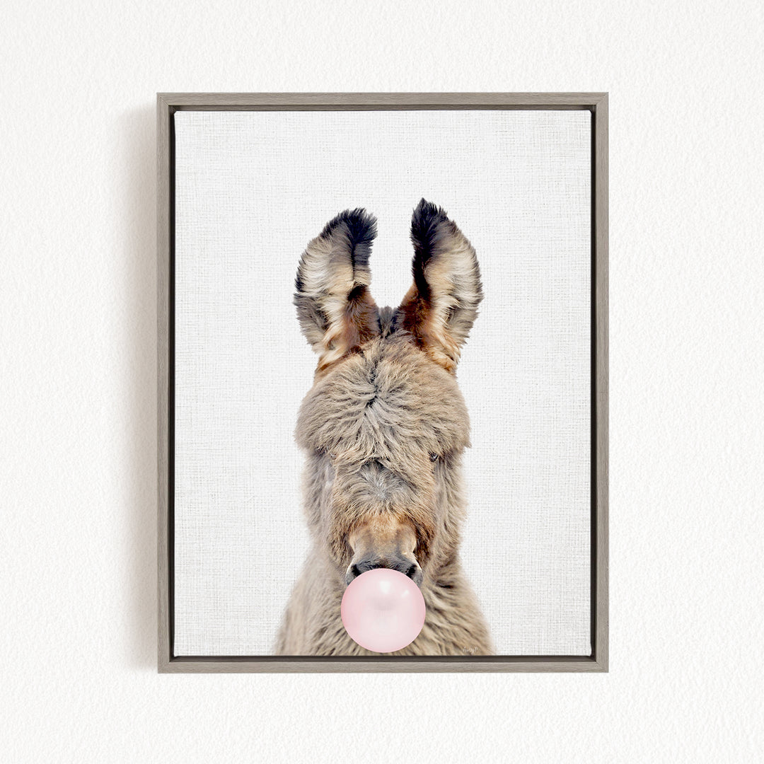 A donkey with its head tilted upwards and a pink bubble gum bubble in its mouth.