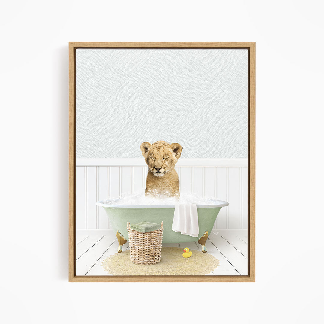 A young lion cub sitting in a green bathtub filled with water, surrounded by a basket of toys and a yellow rubber duck.