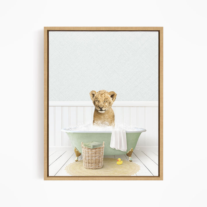 A young lion cub sitting in a green bathtub filled with water, surrounded by a basket of toys and a yellow rubber duck.