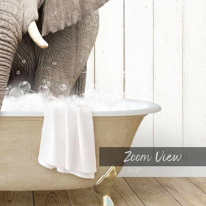 A large elephant is taking a bath in a bathtub filled with bubbles, with a towel hanging on the side of the tub.